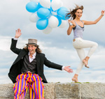 Man on stilts and woman with balloons