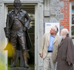 Men speaking beside statue